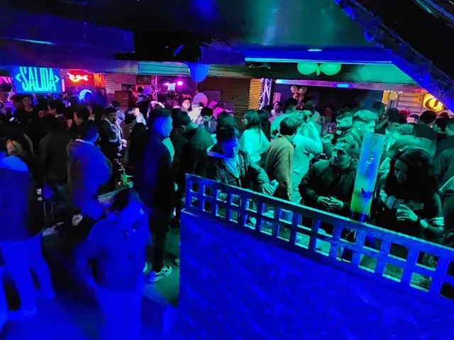Vista del local lleno desde la zona alta, con luces azules