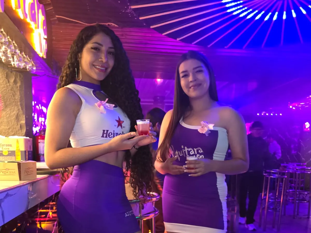 Anfitrionas de Alquitara VIP junto a la barra iluminada
