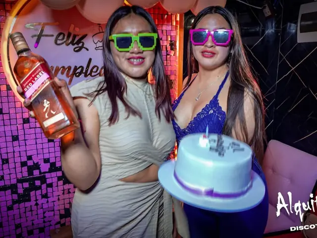 Dos amigas celebrando un cumpleaños con torta y lentes de colores